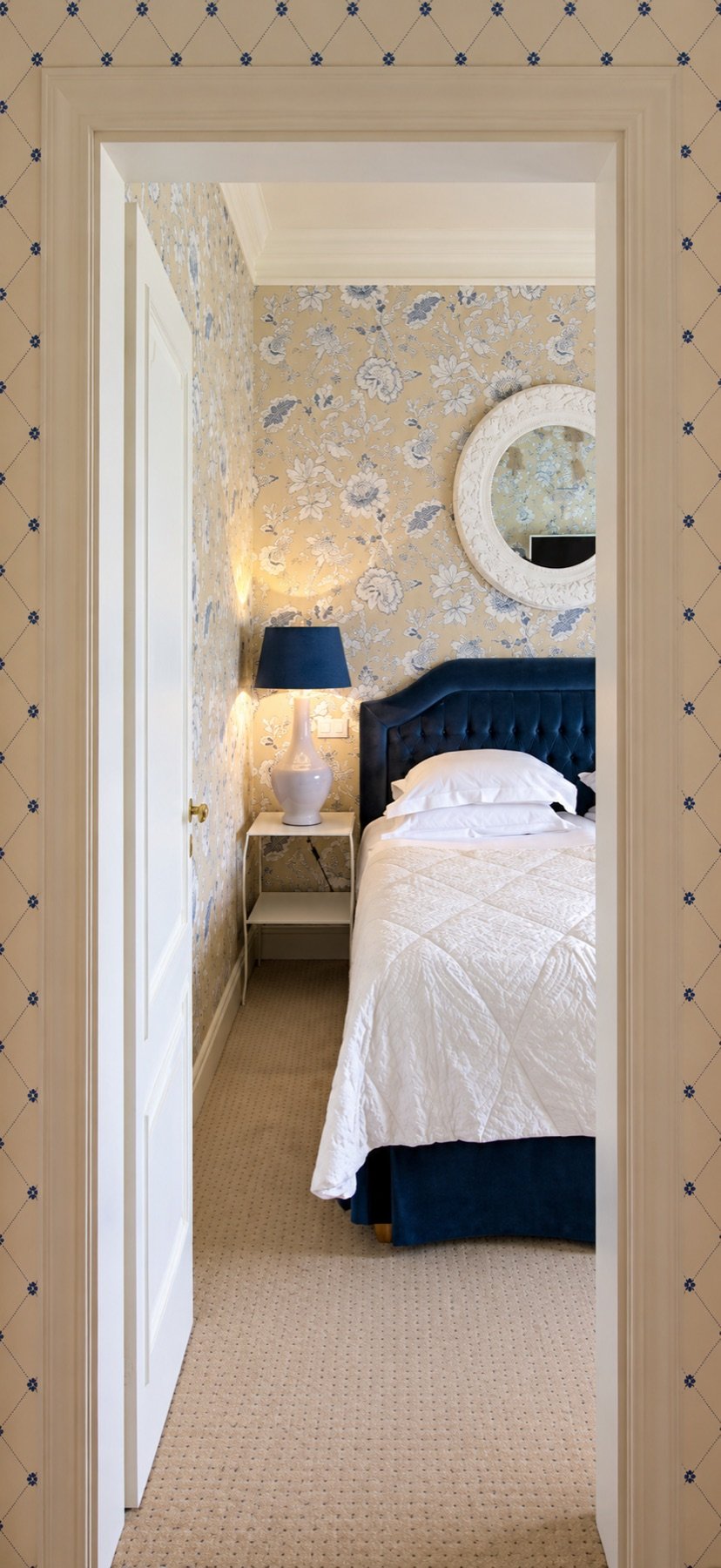 A floral bedroom seen through an open doorway